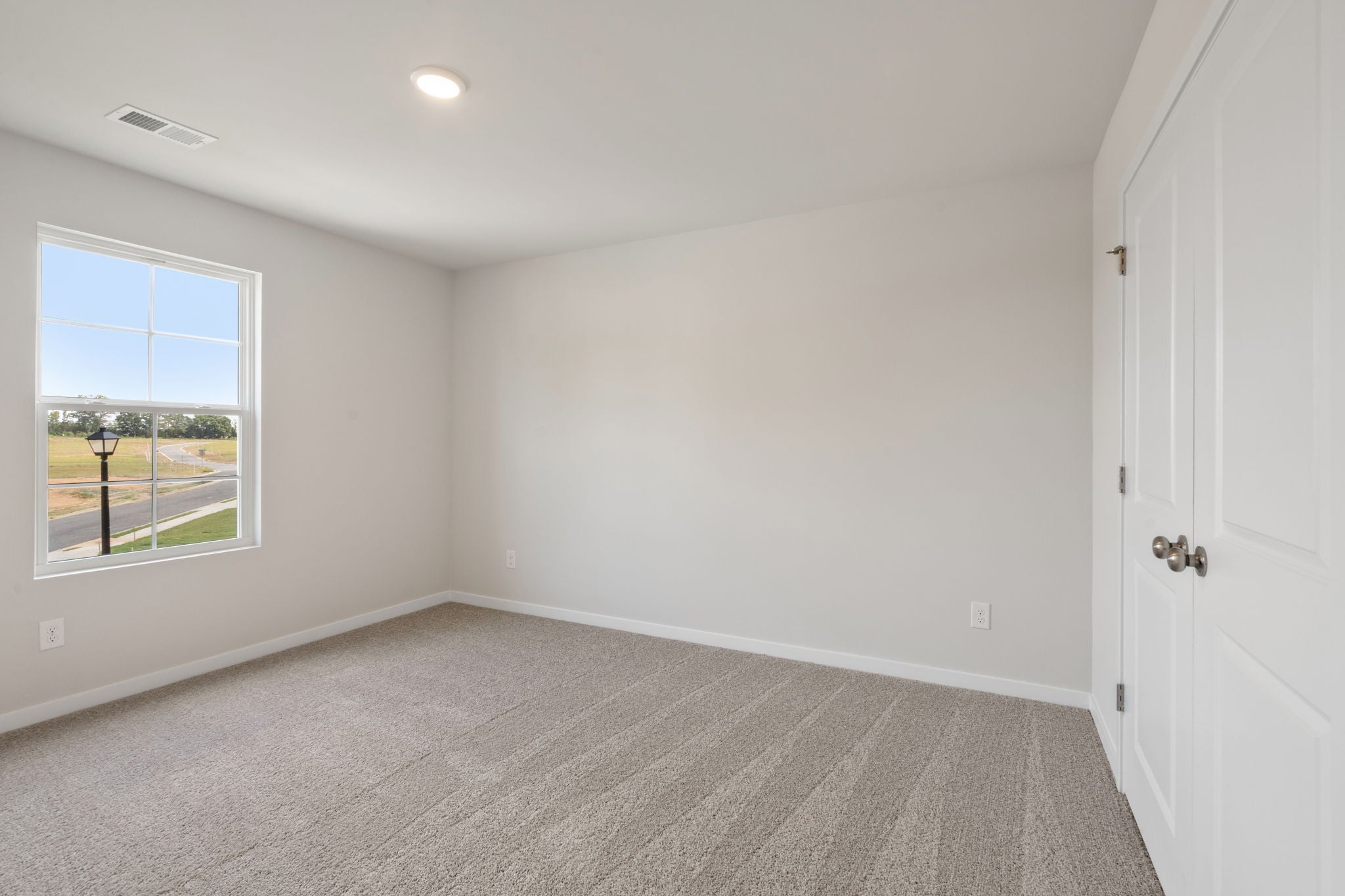 A room with a window and a carpet.