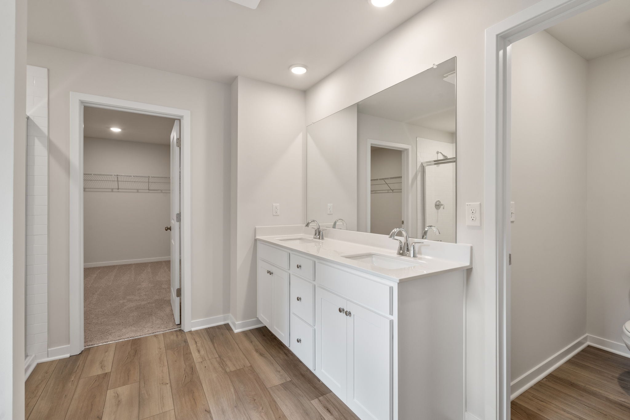 A bathroom with white cabinets.
