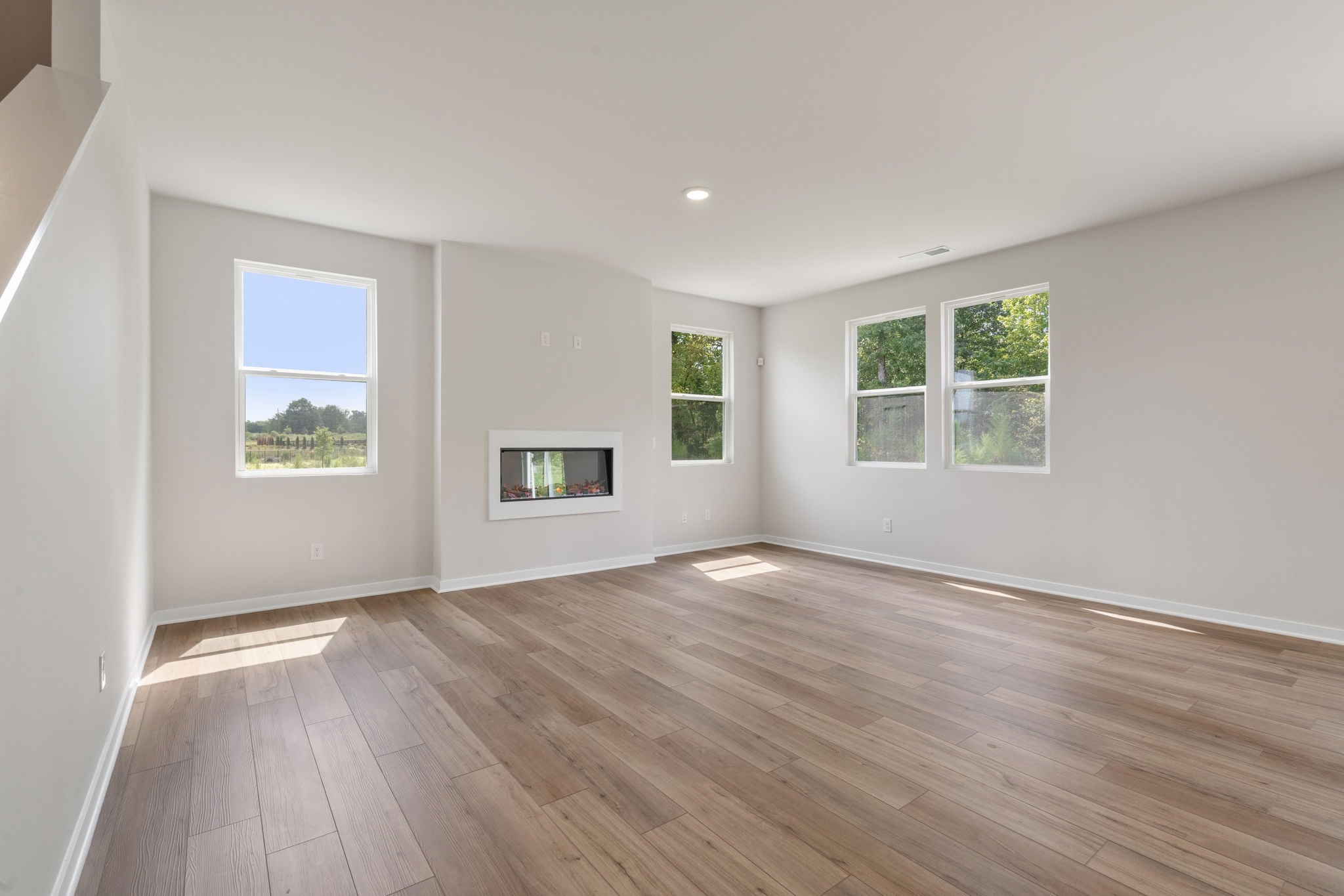 A room with windows and a wood floor.