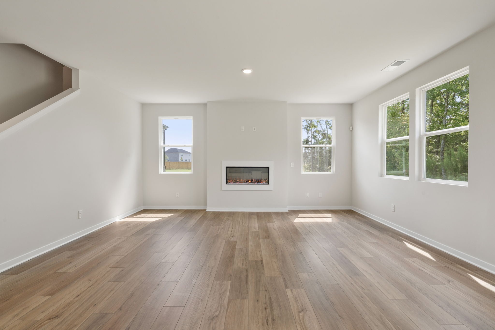A room with a wood floor and windows.