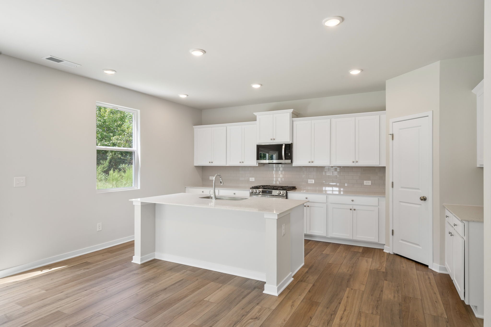 A kitchen with white cabinets.