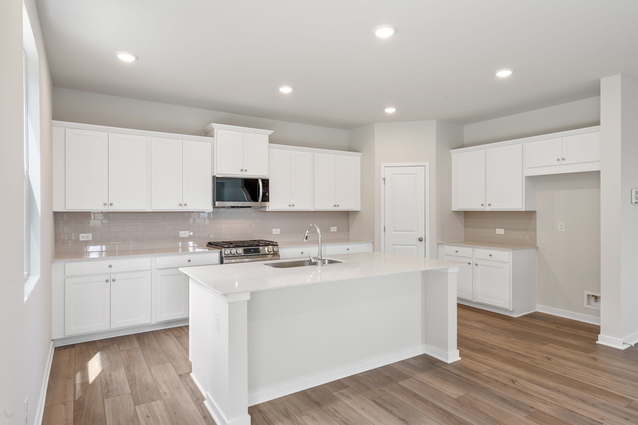 A kitchen with white cabinets.