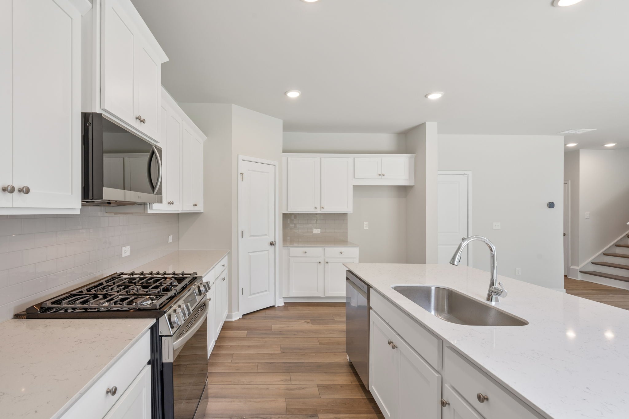 A kitchen with white cabinets.