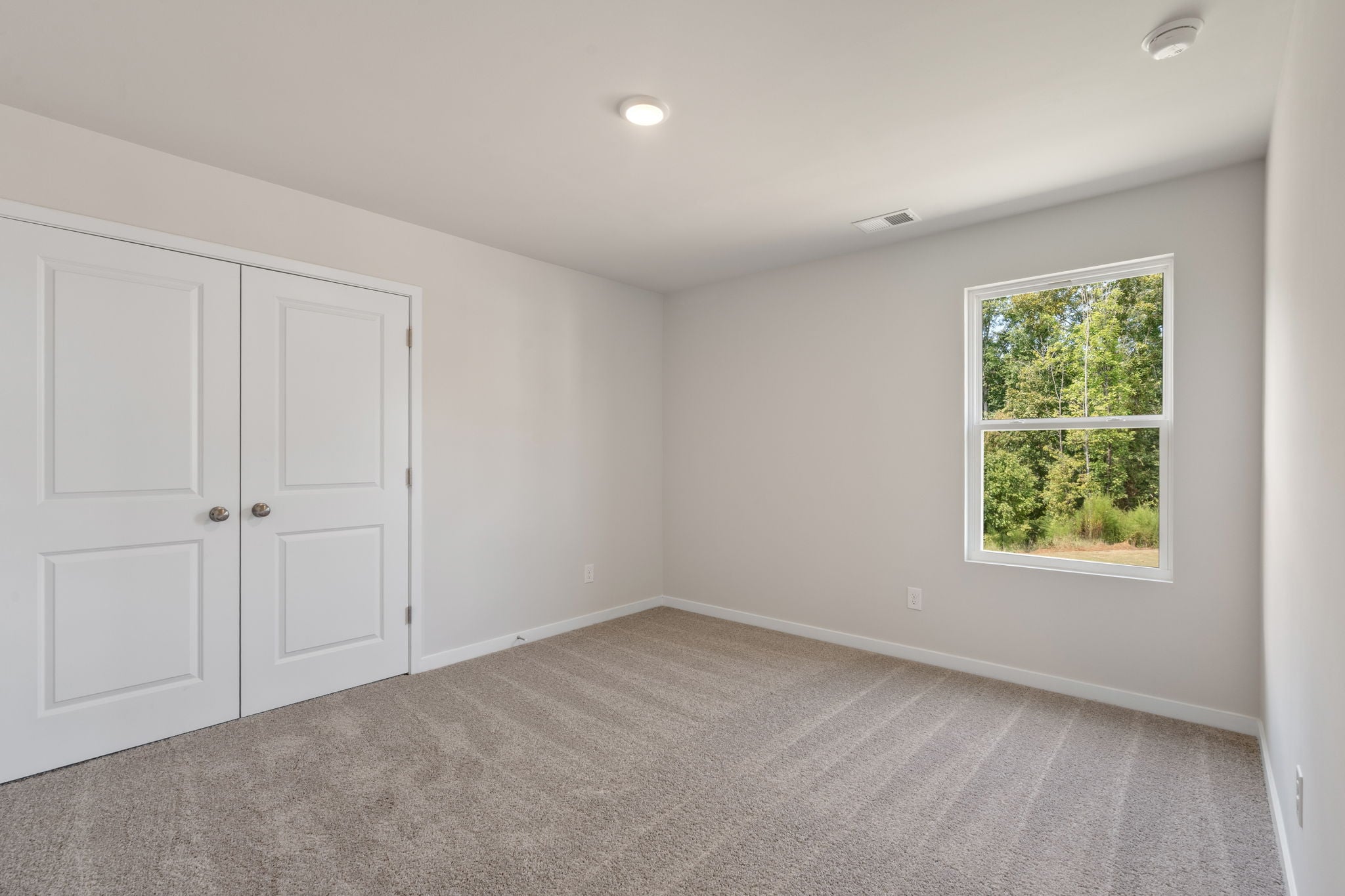 A room with white doors and a window.