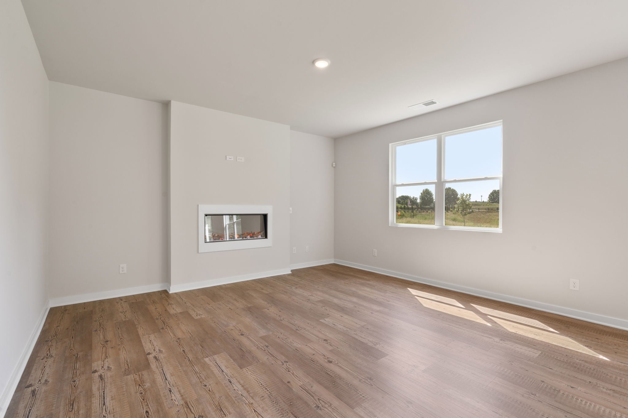A room with a wood floor and windows.