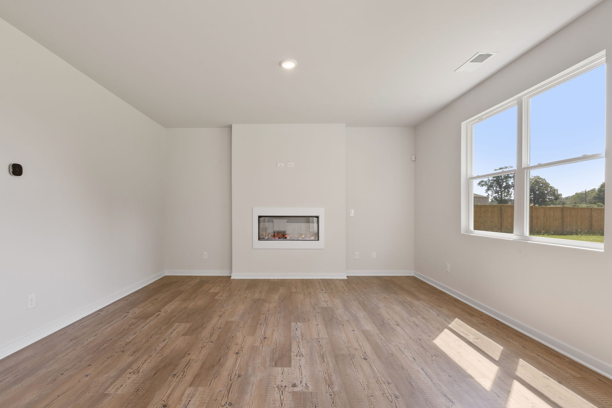 A room with a wood floor and a window with a wood floor.