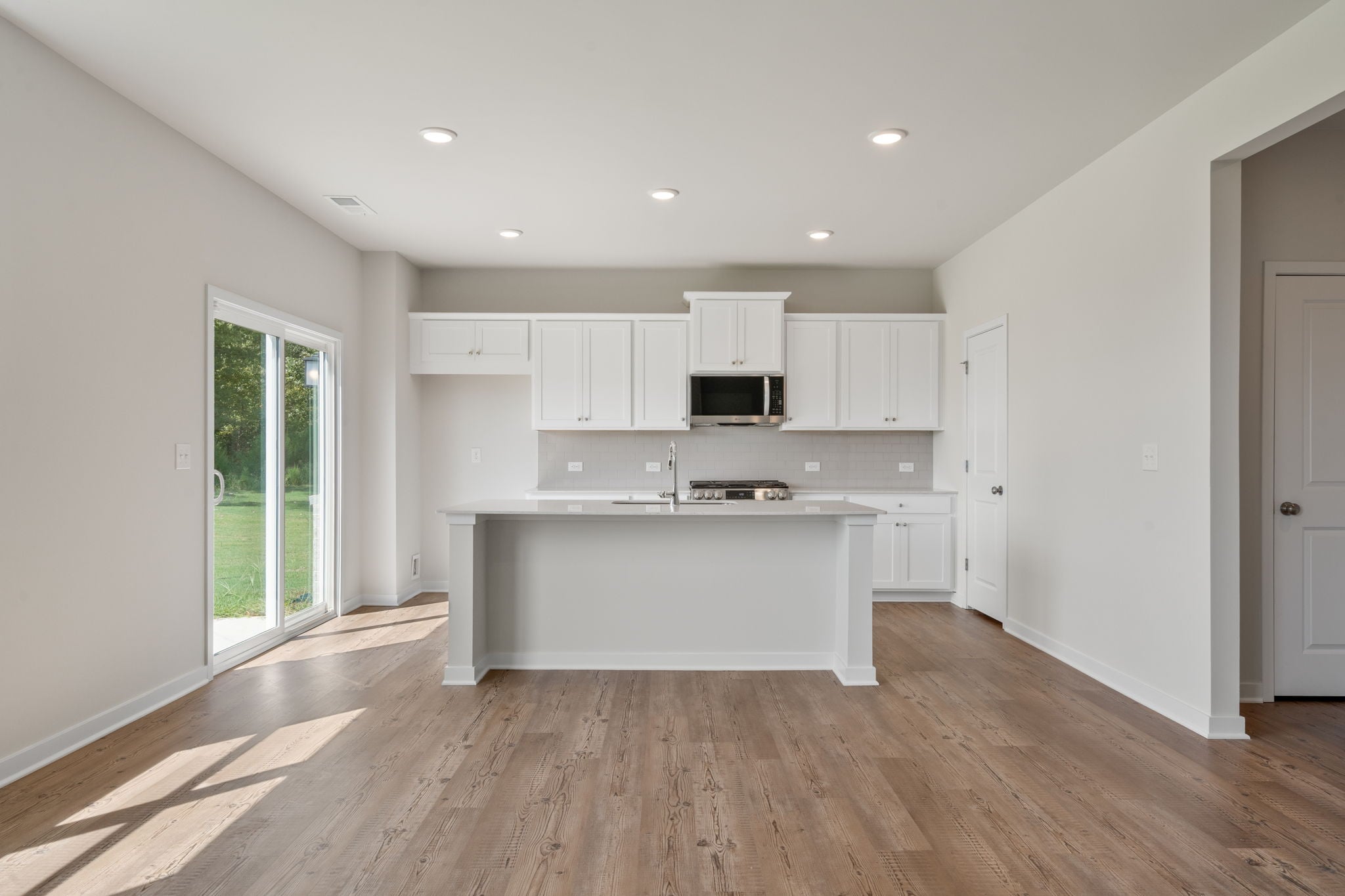 A kitchen with white cabinets.
