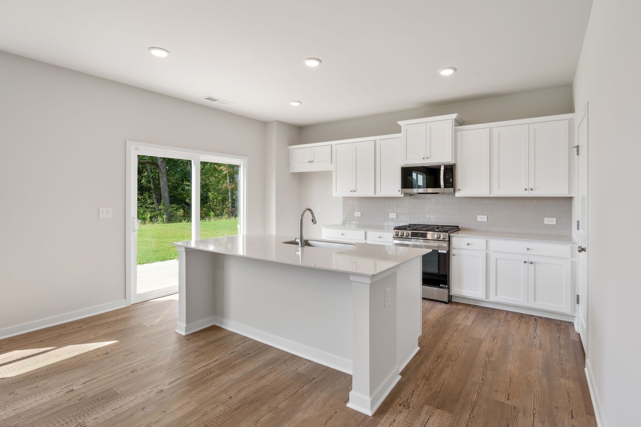 A kitchen with white cabinets.