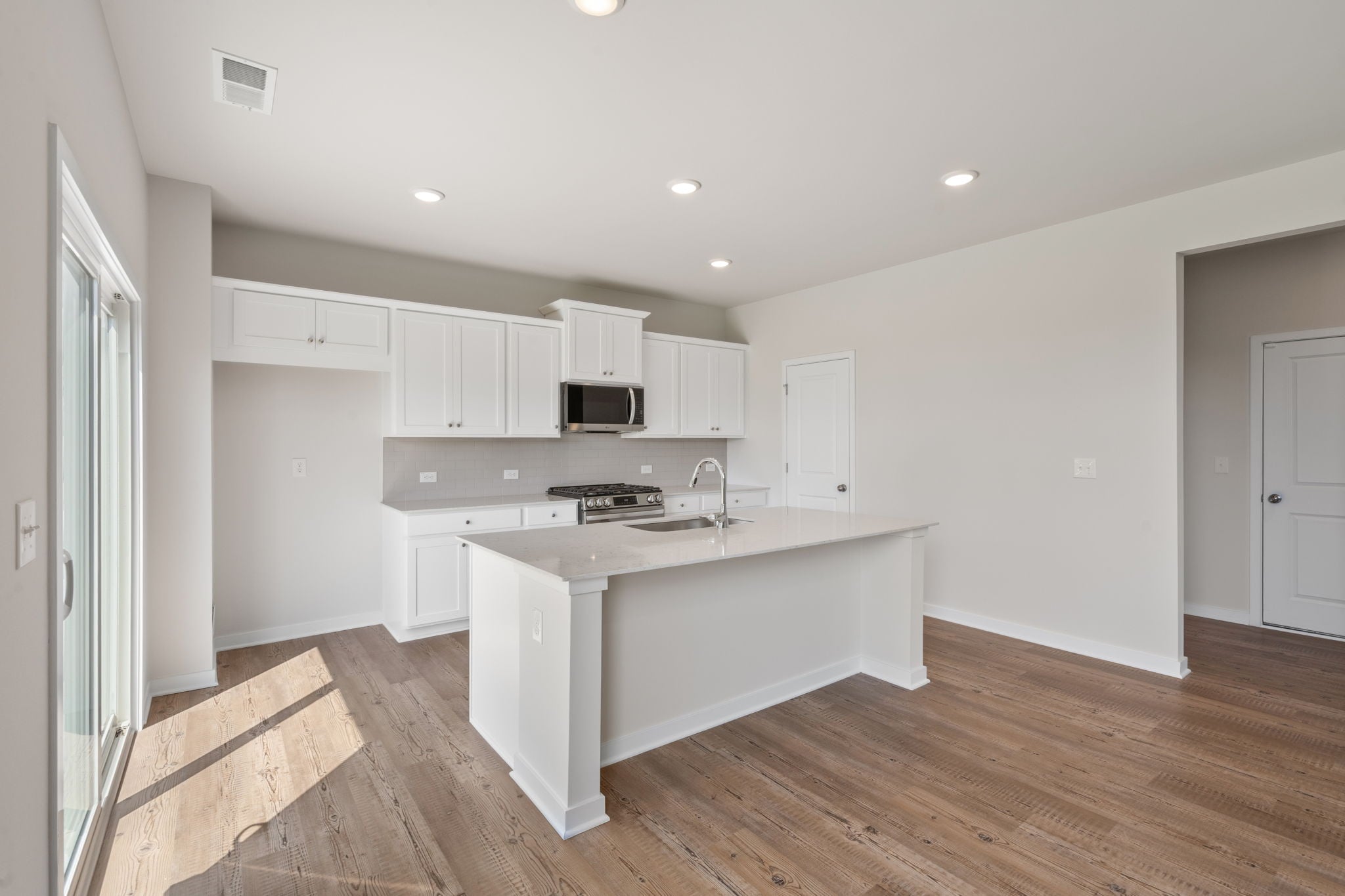 A kitchen with white cabinets.