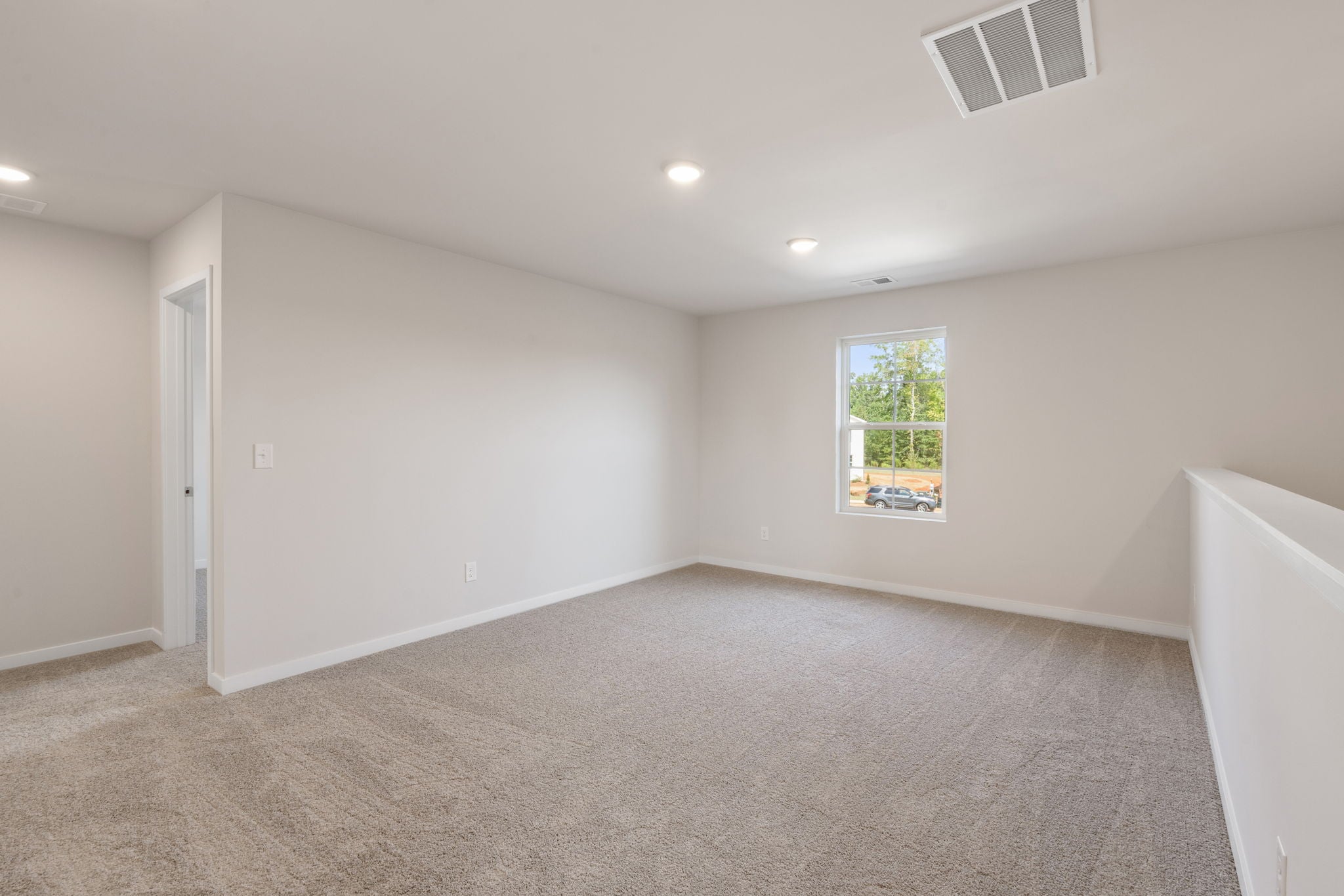 A room with a window and a carpet.