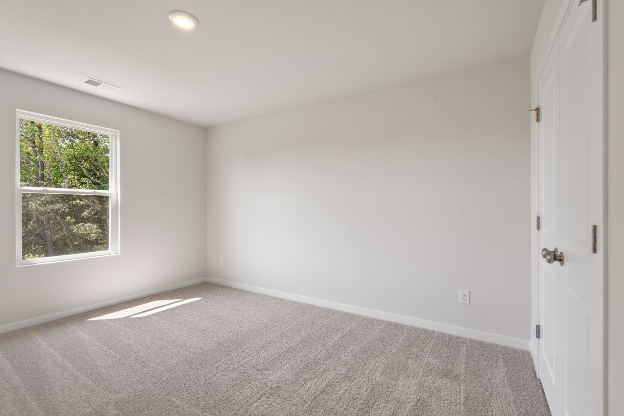 A room with a carpet and a window.