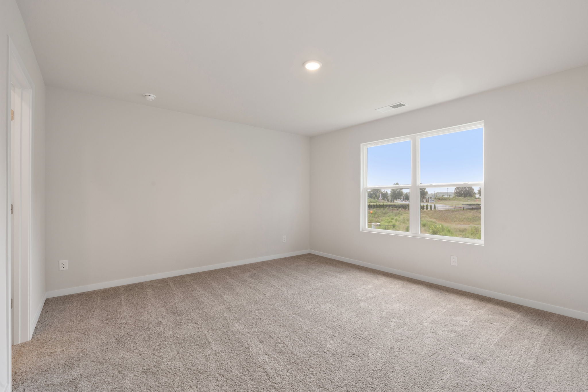A room with a window and a carpet.