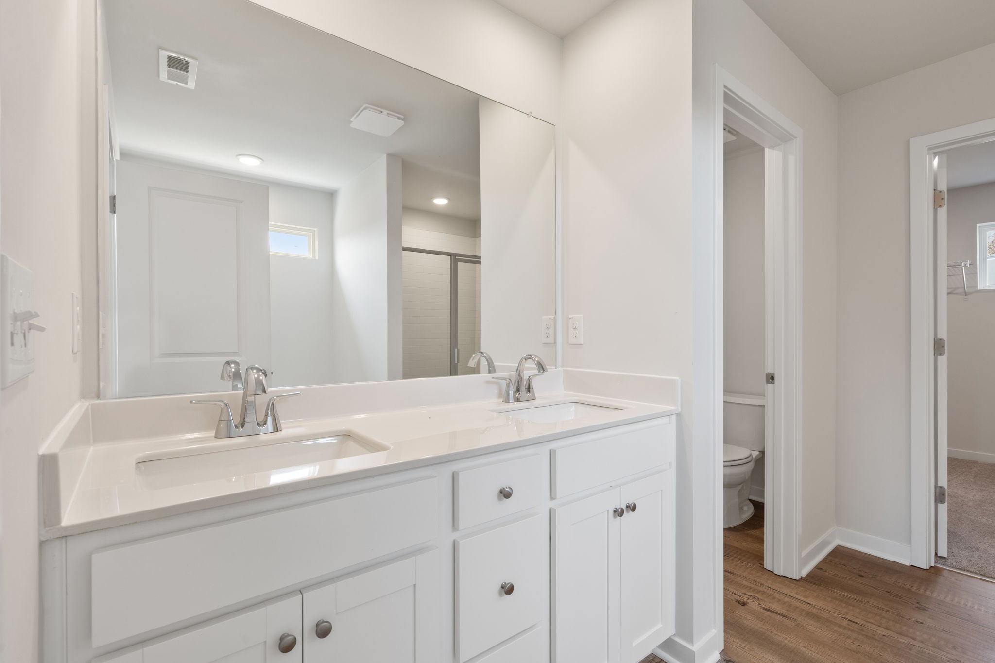 A bathroom with white cabinets.