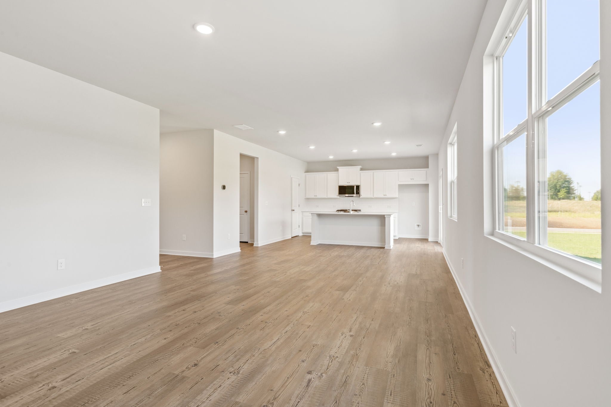 A large empty room with a wood floor and a wood floor.
