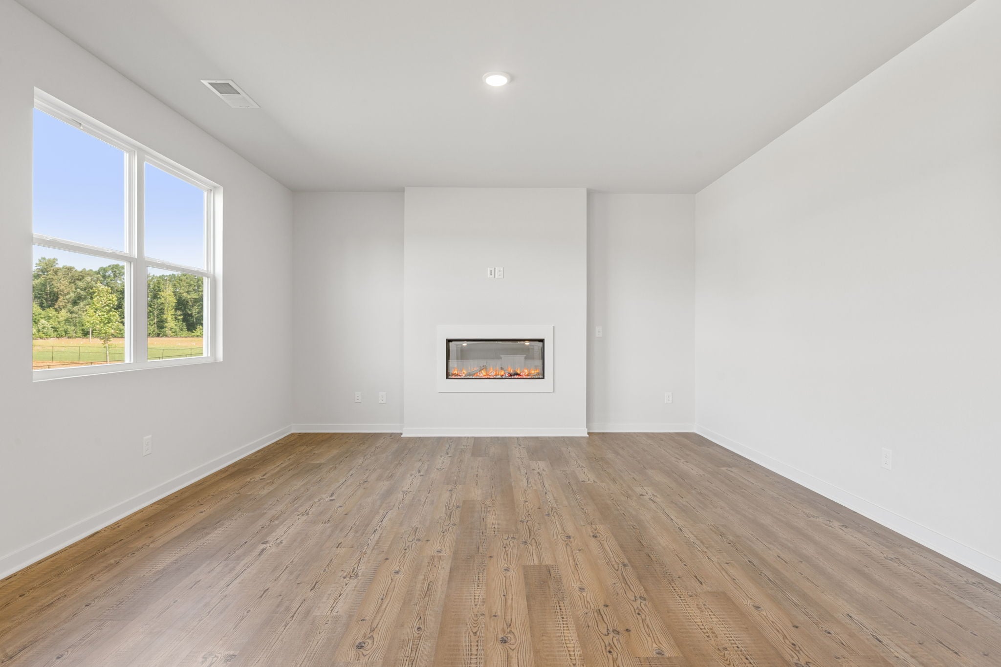 A room with a wood floor and a window with a picture on it.