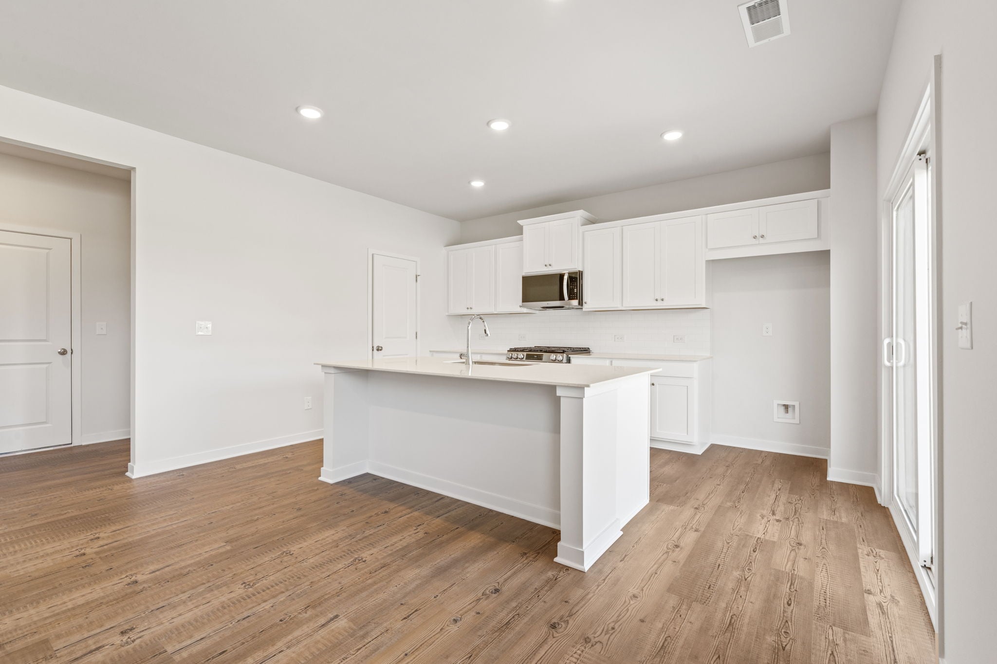 A kitchen with white cabinets.
