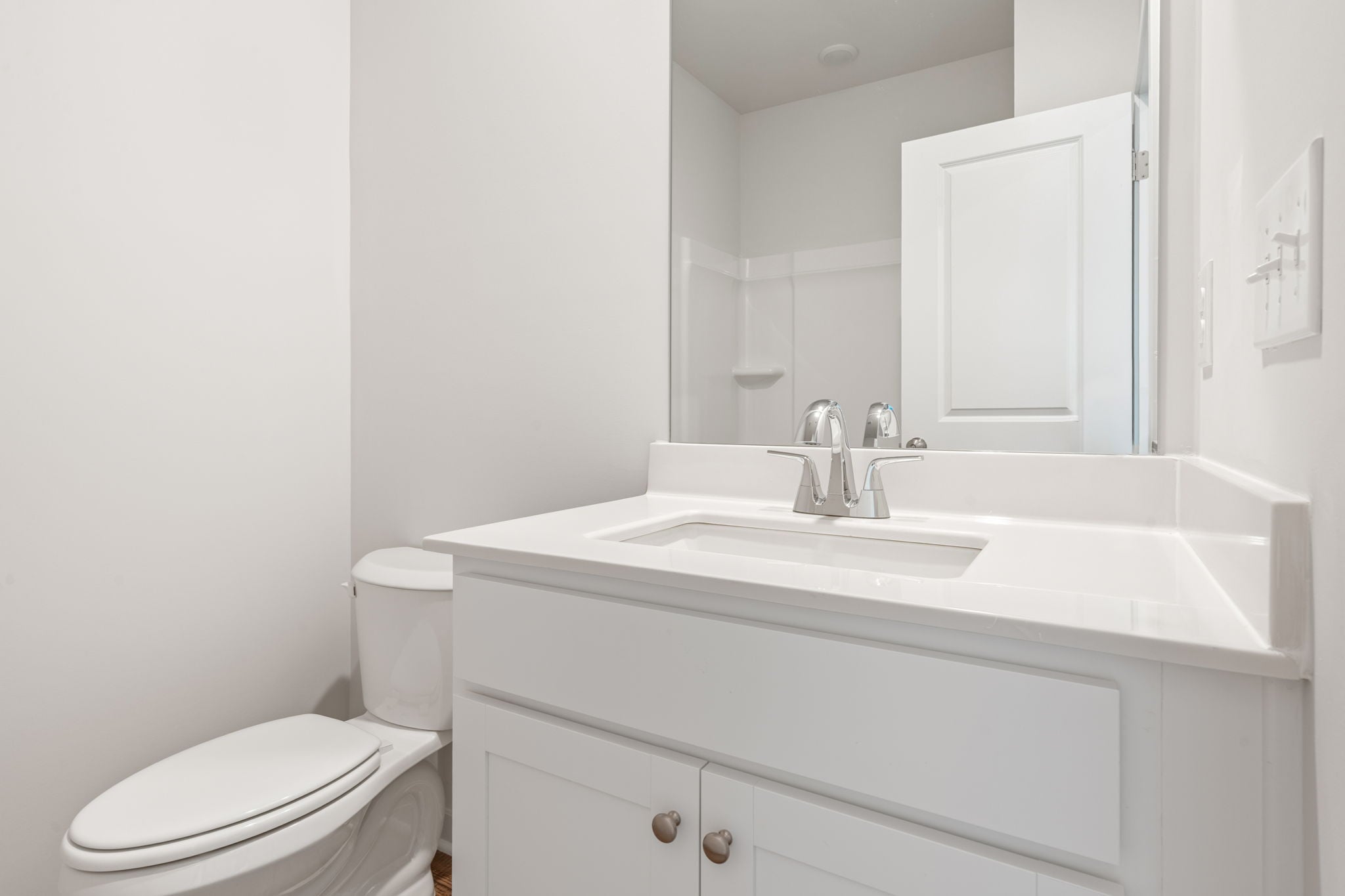 A bathroom with a sink toilet and mirror.