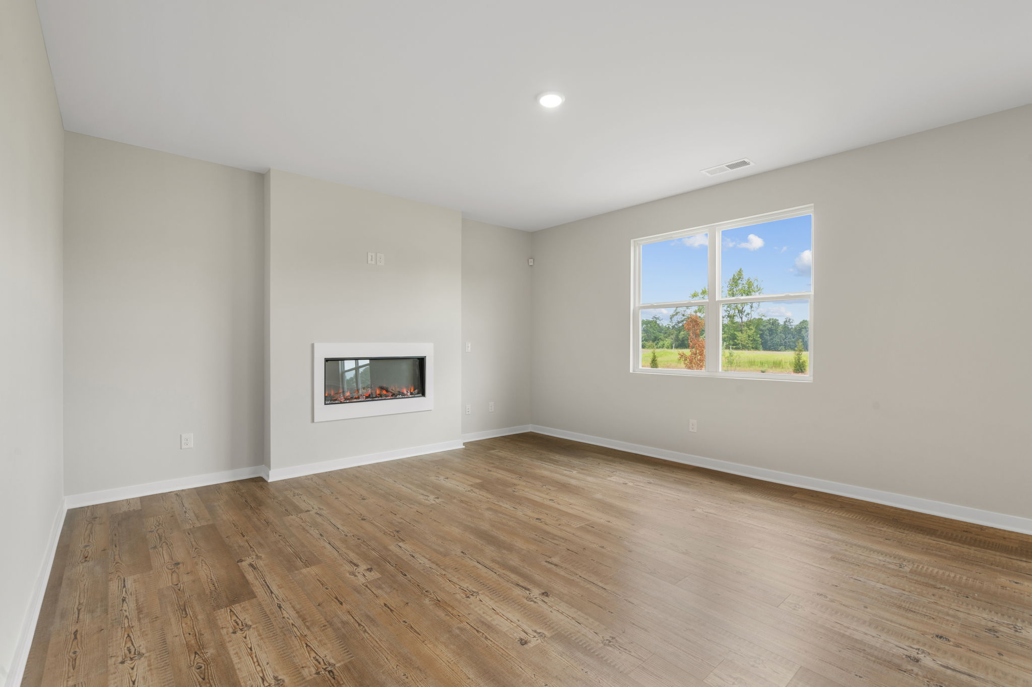 A room with a wood floor and a window with a painting on it.