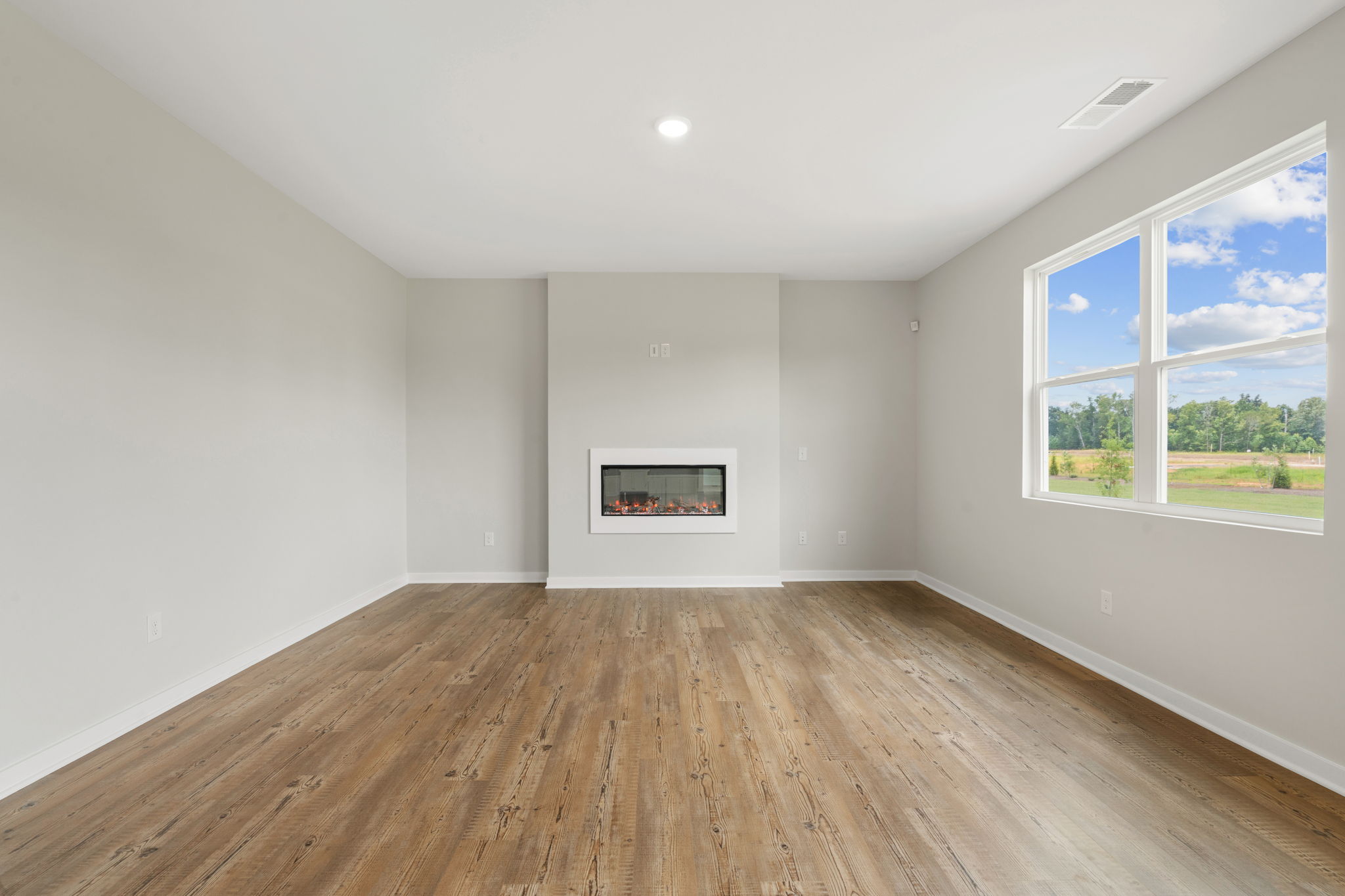 A room with a wood floor and a window with a painting on it.