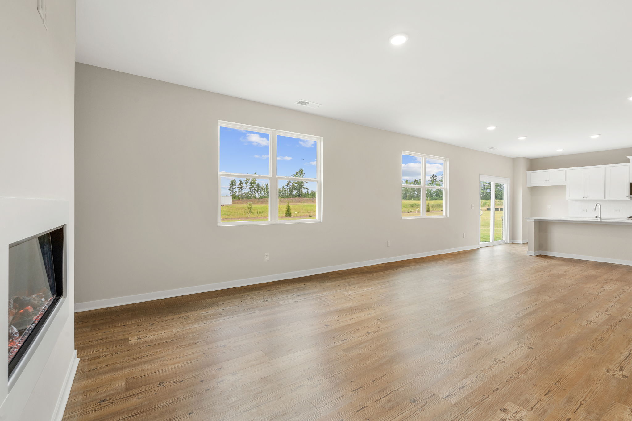 A room with a wood floor and a television and a wood floor.