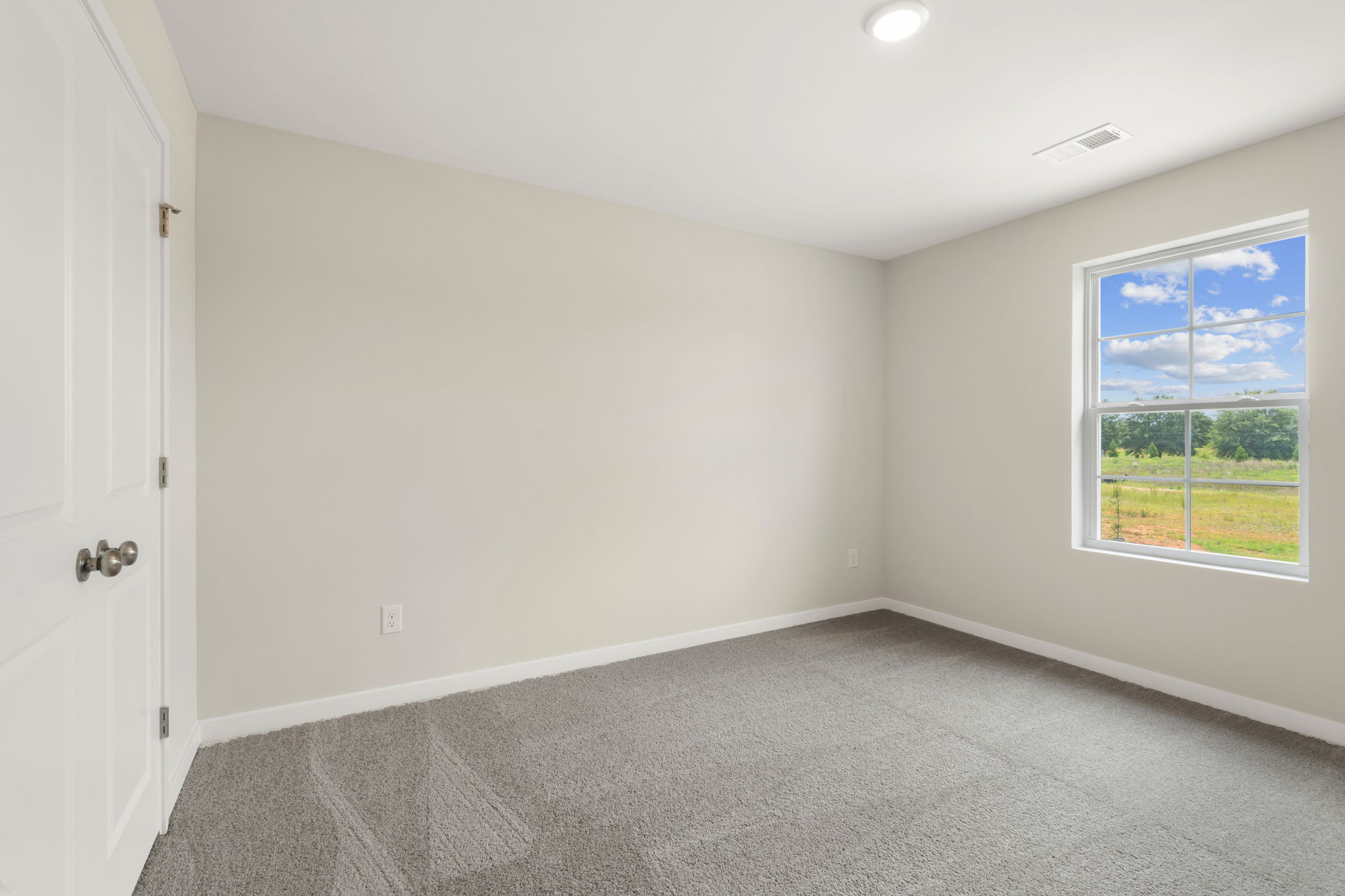 A room with a window and a carpet.