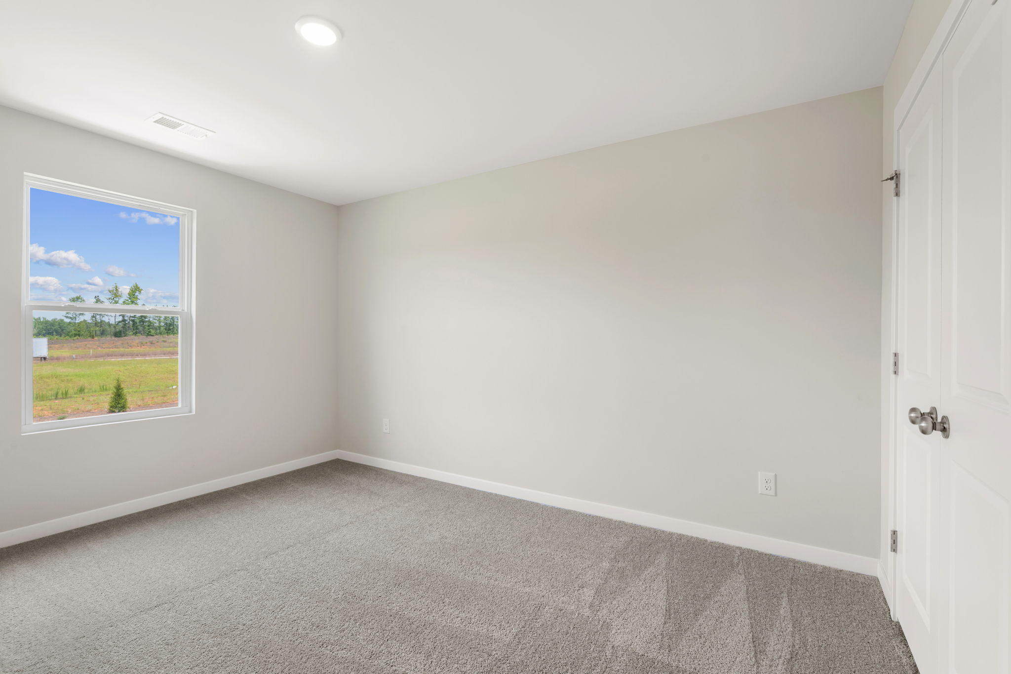 A room with a window and a carpet.
