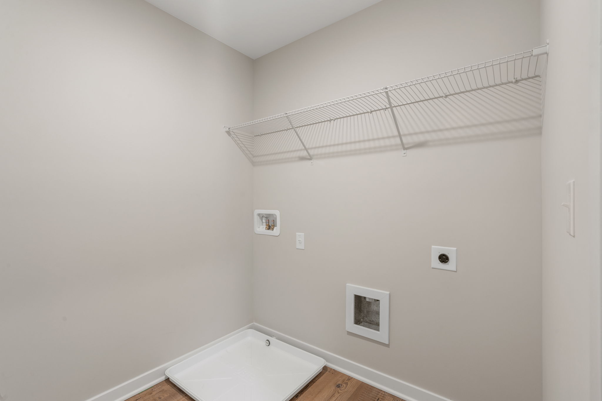 A white bathroom with a white wall.
