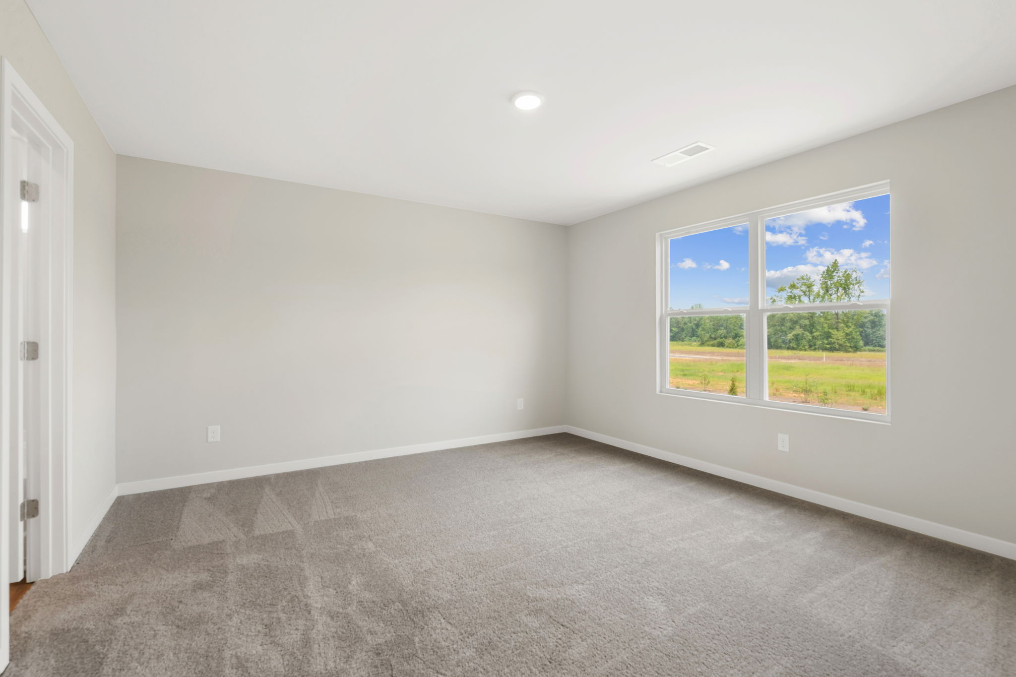 A room with a window and a carpet.