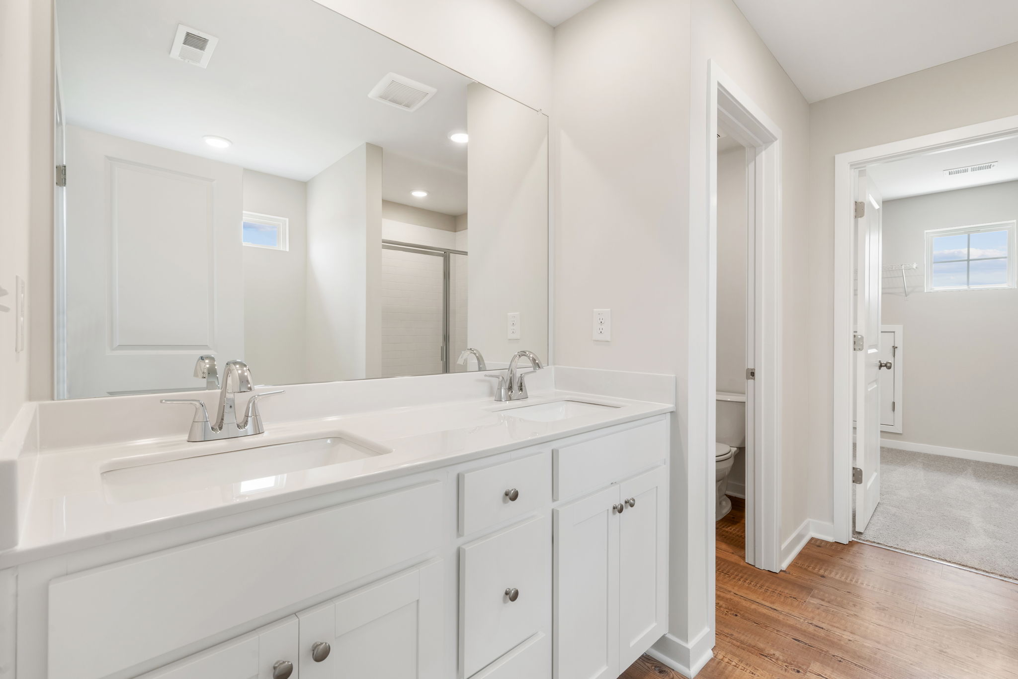 A bathroom with white cabinets.