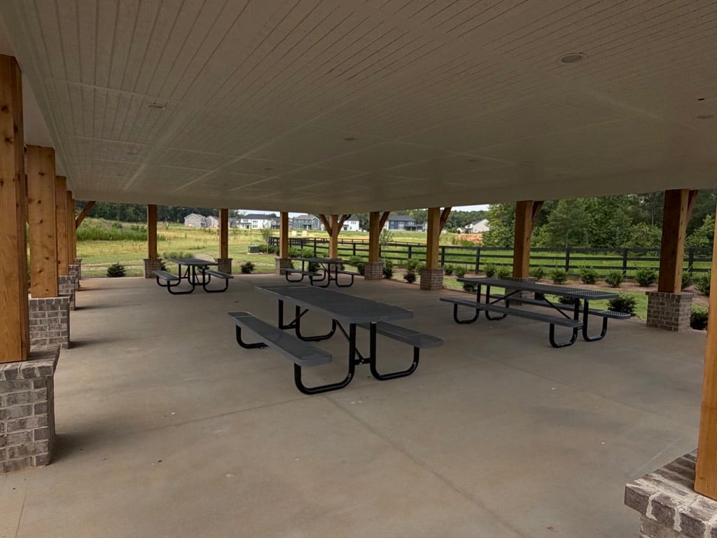 A covered patio with tables and chairs.