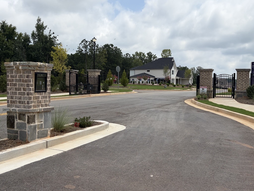 A gated driveway leading to a house.