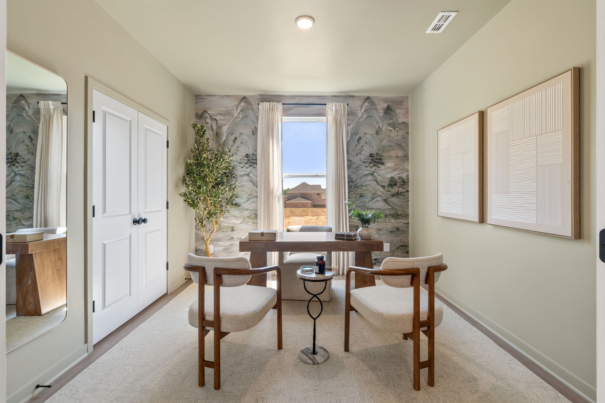 A room with a table chairs and a window with a view of the ocean.
