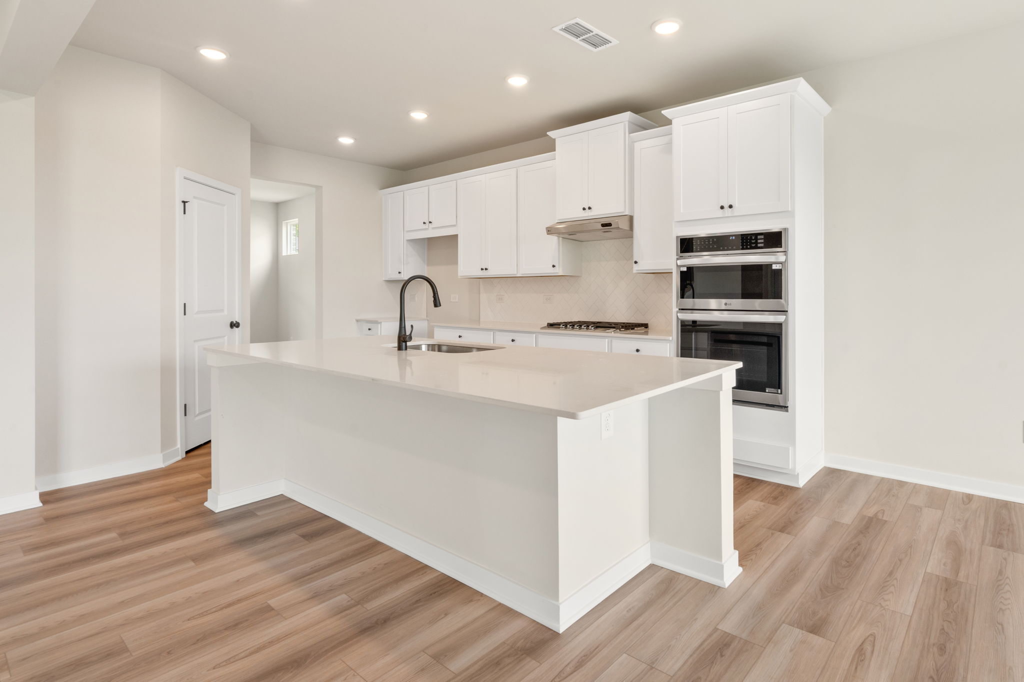 A kitchen with white cabinets.
