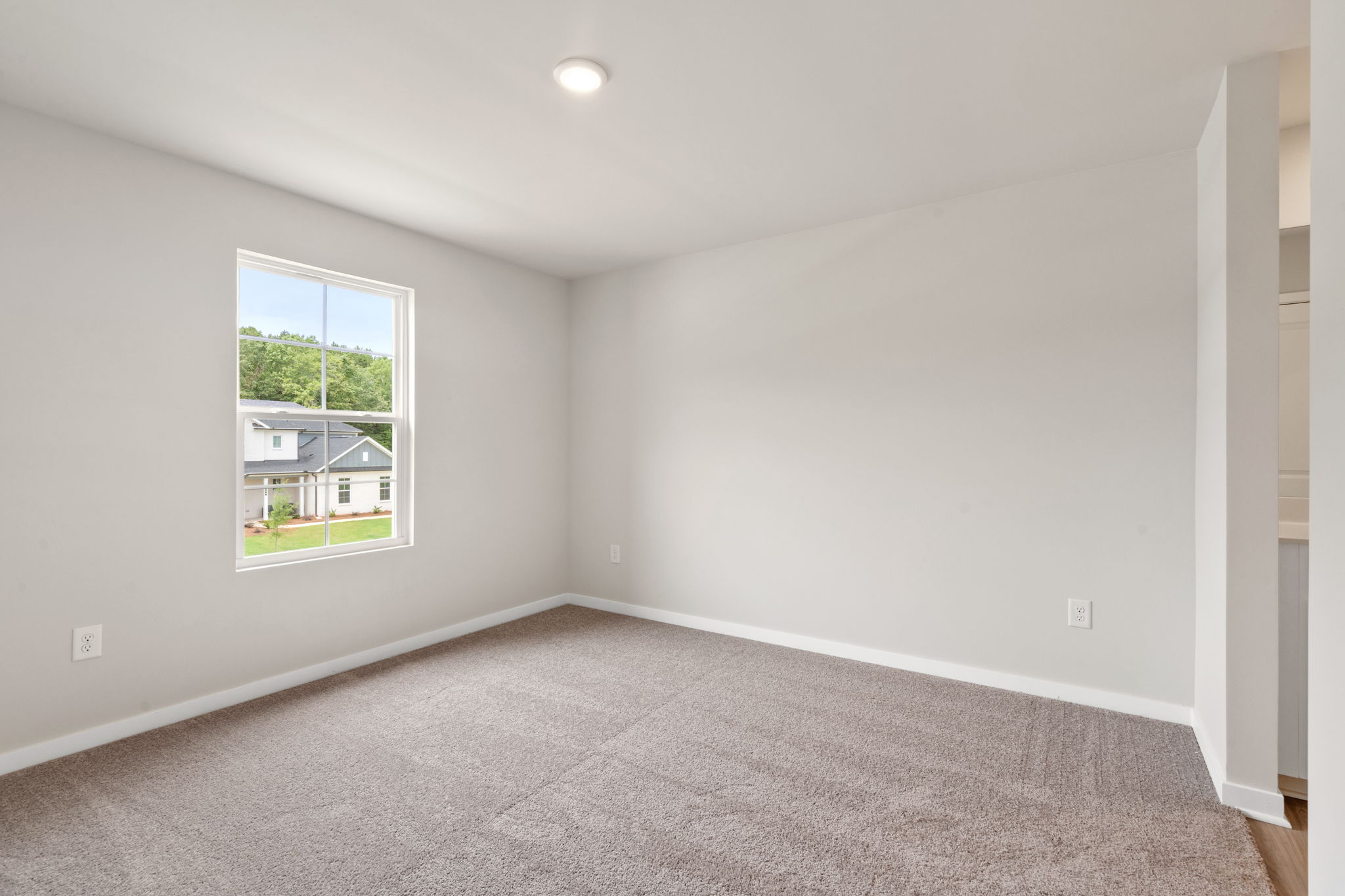 A room with a window and a carpet.