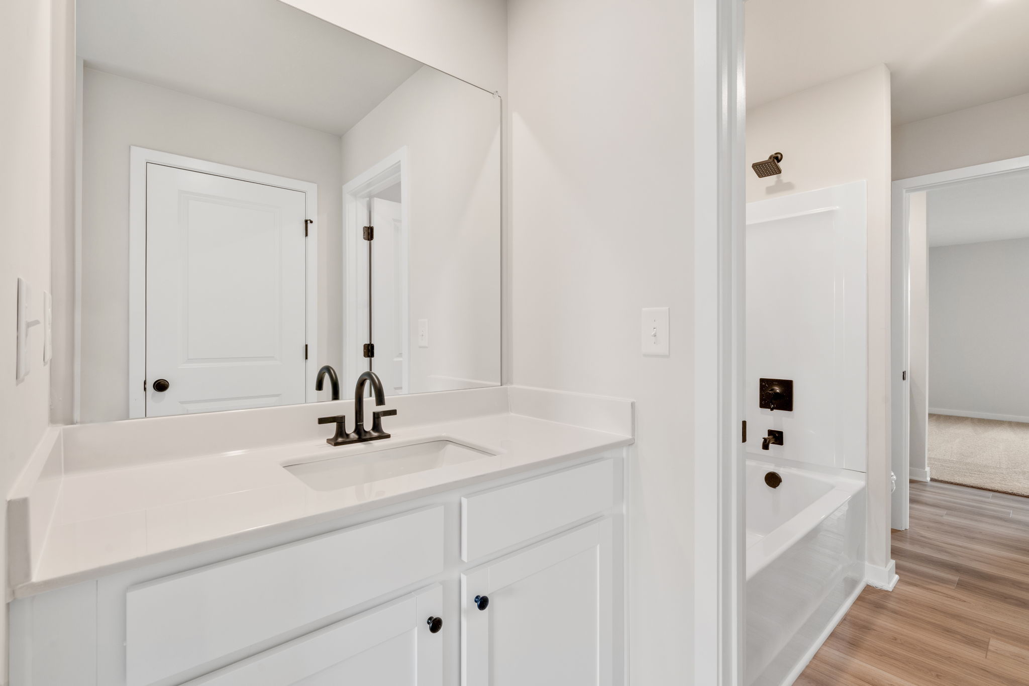 A bathroom with white cabinets.