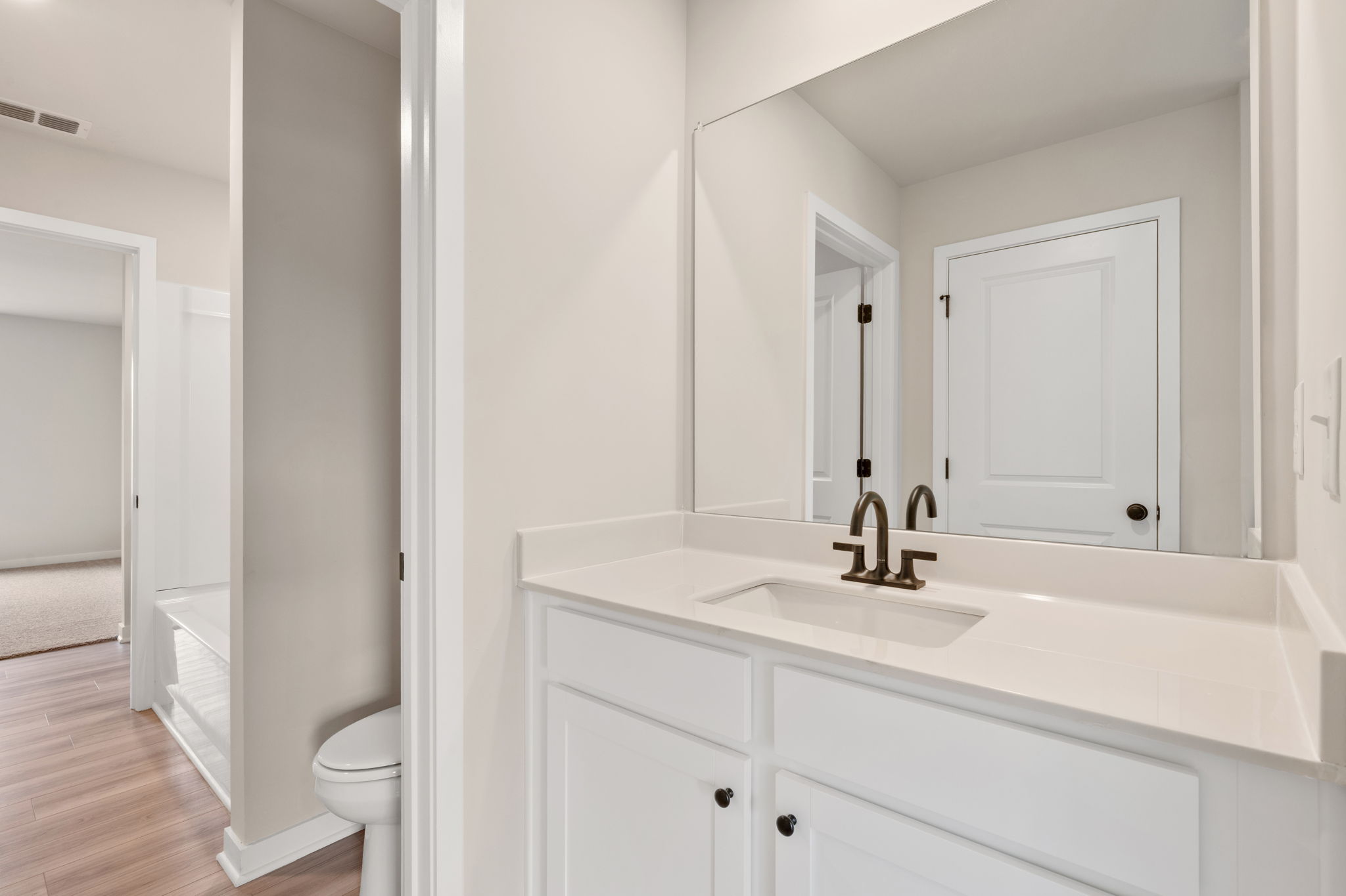 A bathroom with white cabinets.