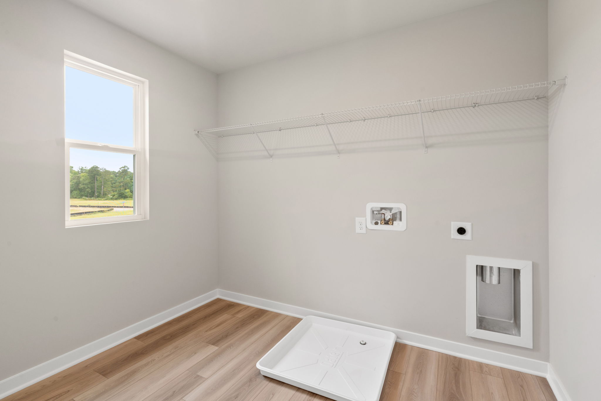 A room with a window and a wood floor.