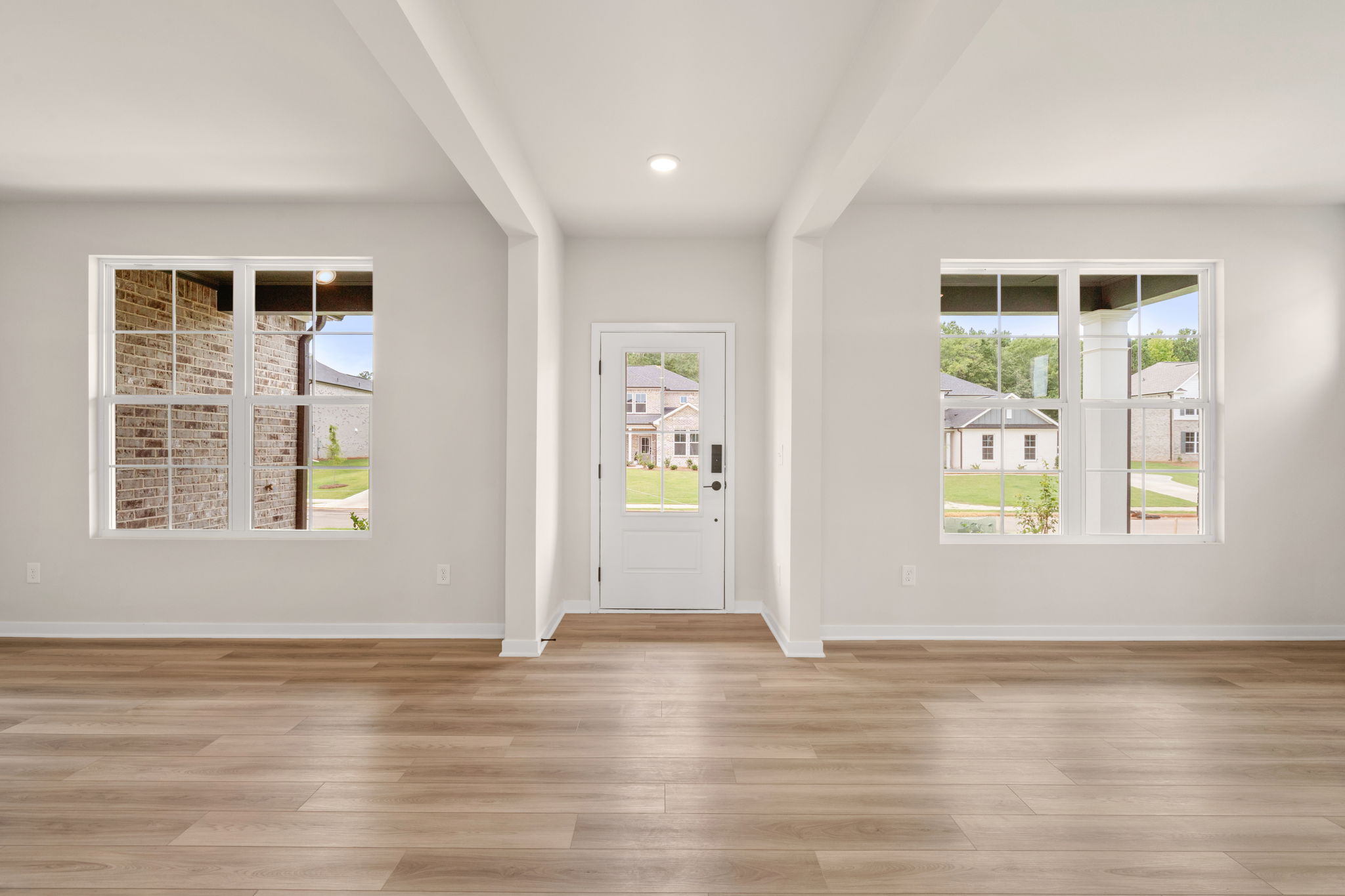 A room with windows and a wood floor.