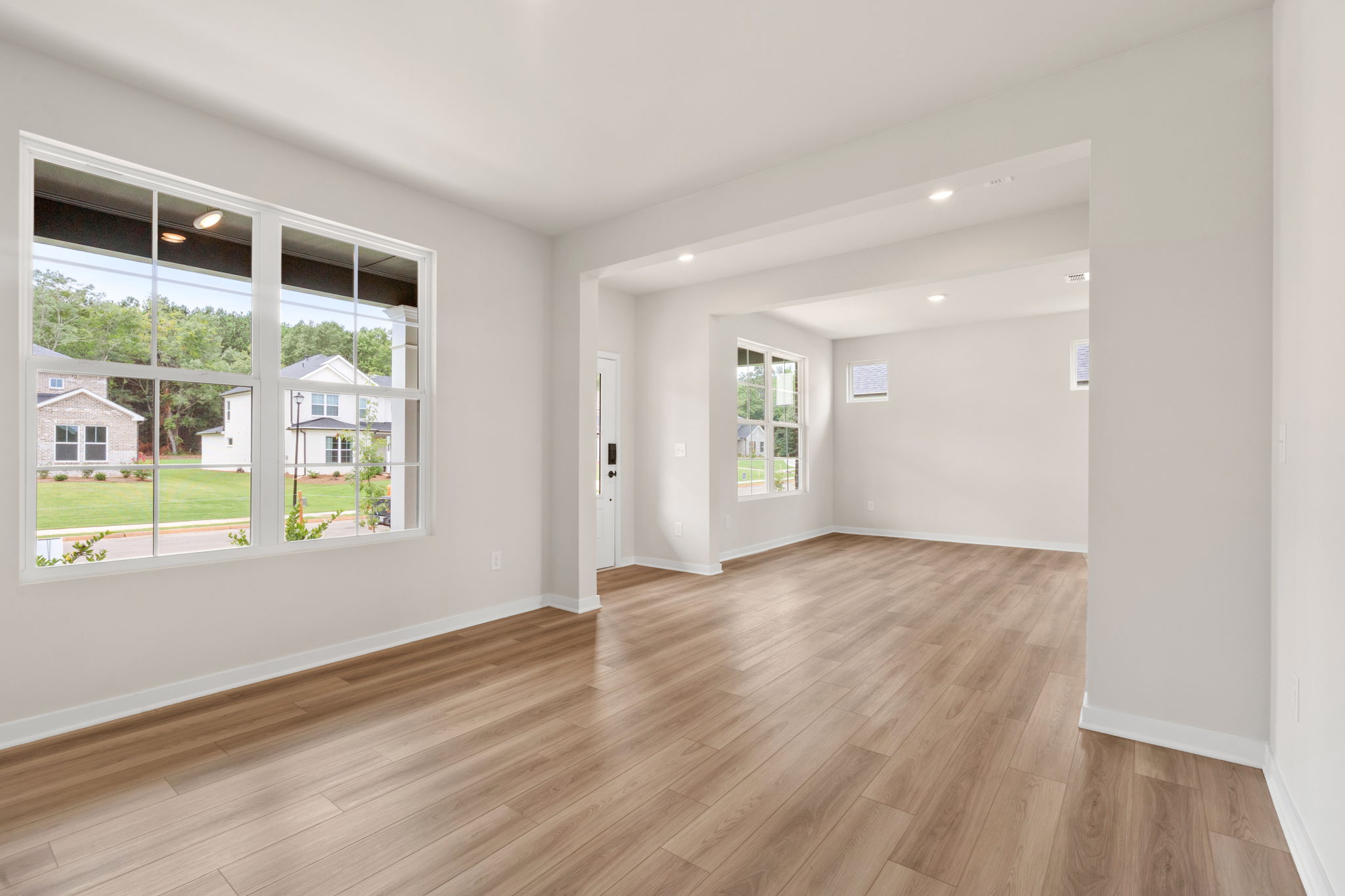 A room with a wood floor and a large window.