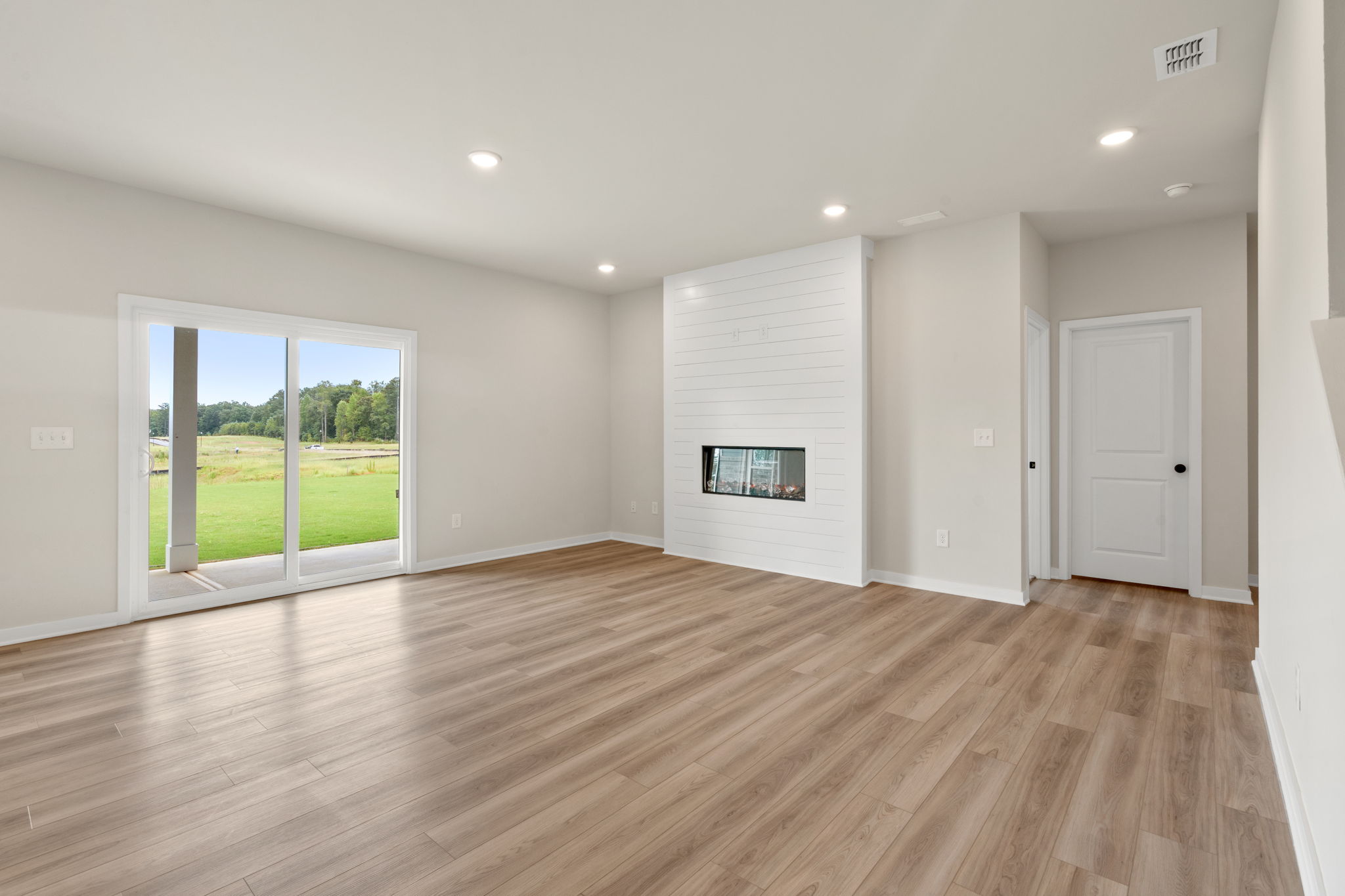 A room with a wood floor and a wood floor with a window.