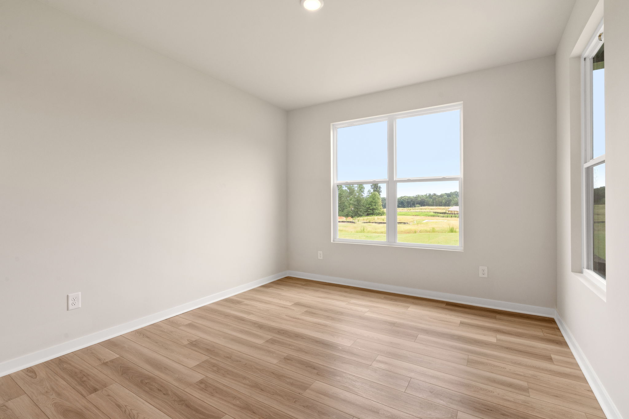 A room with a wood floor and windows.