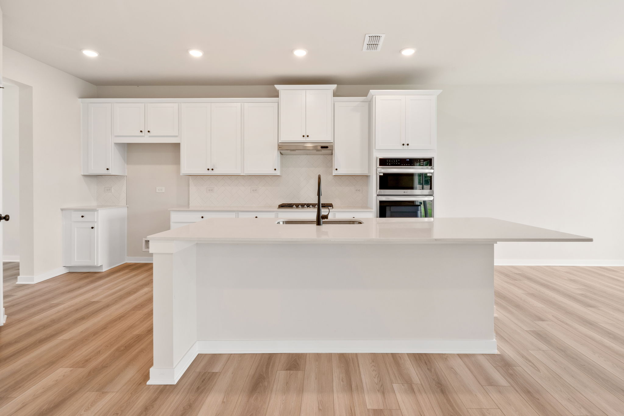A kitchen with white cabinets.