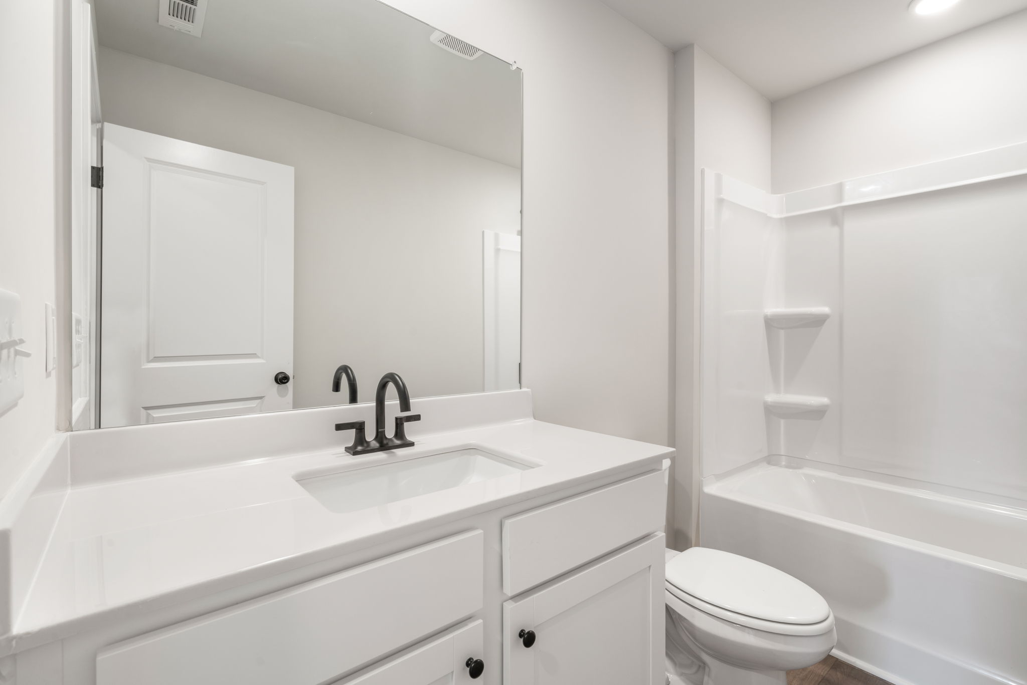 A bathroom with a sink toilet and bathtub.