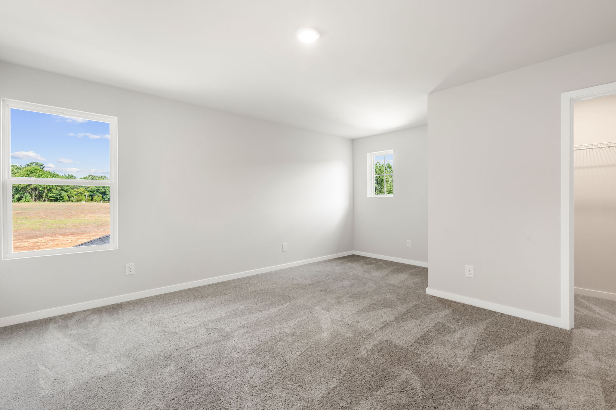 A room with a window and a carpet.
