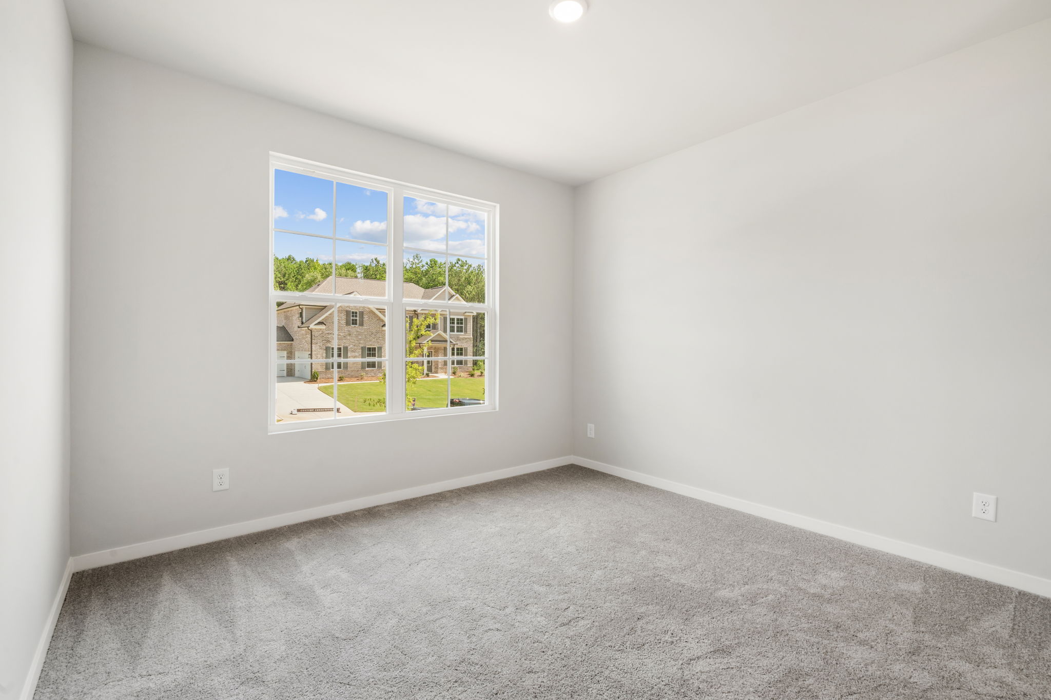 A room with a window and a carpet.