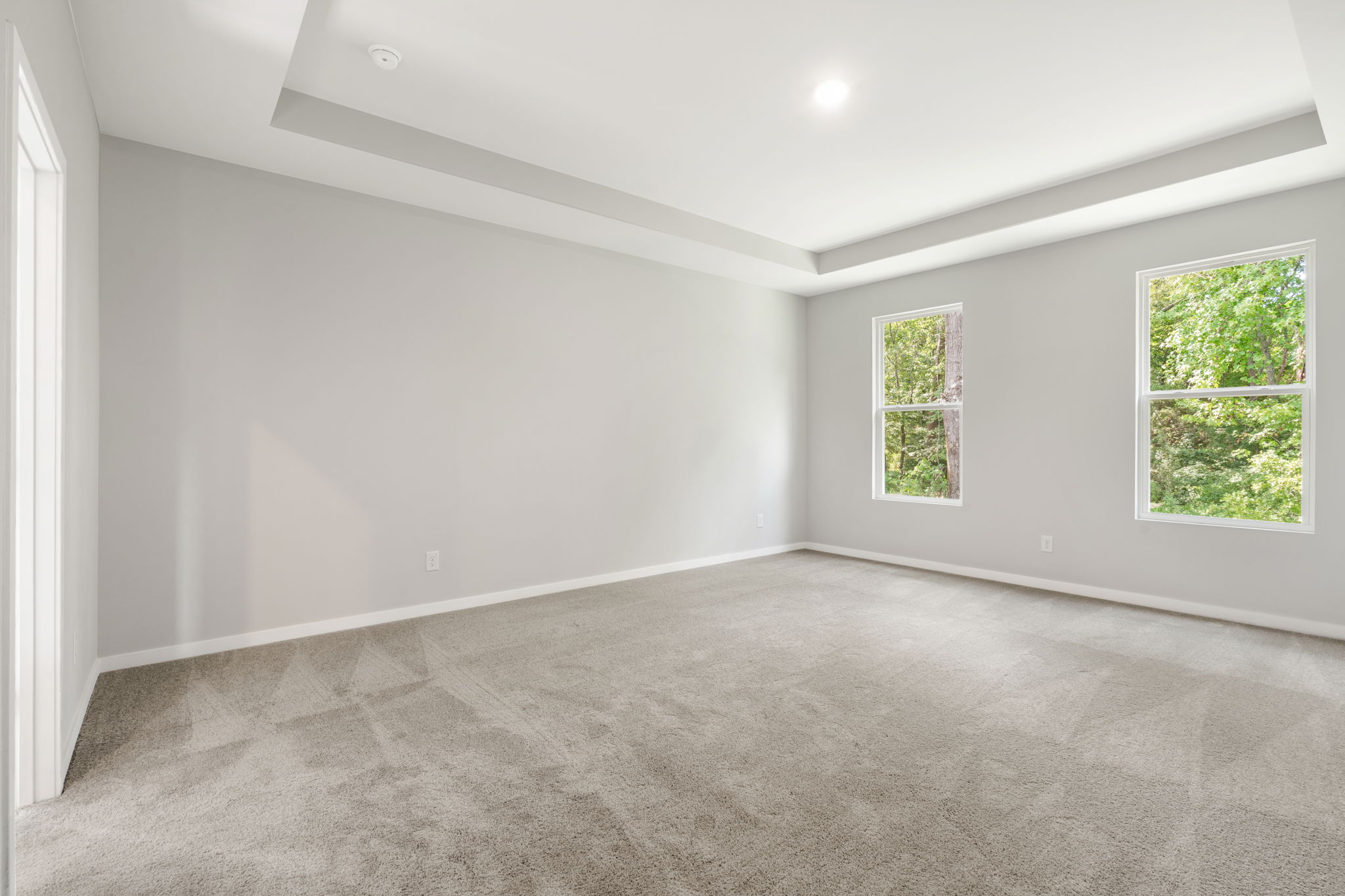 A room with a carpet and windows.