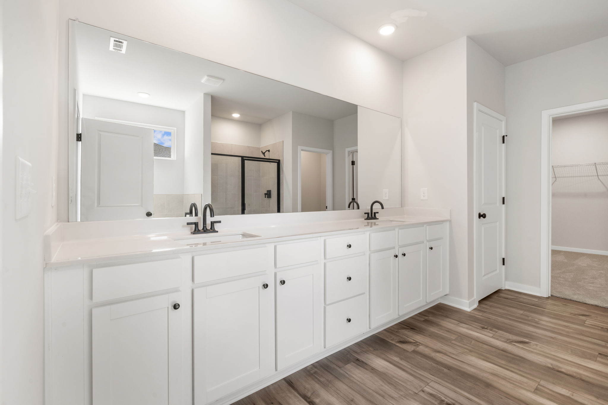 A bathroom with white cabinets.