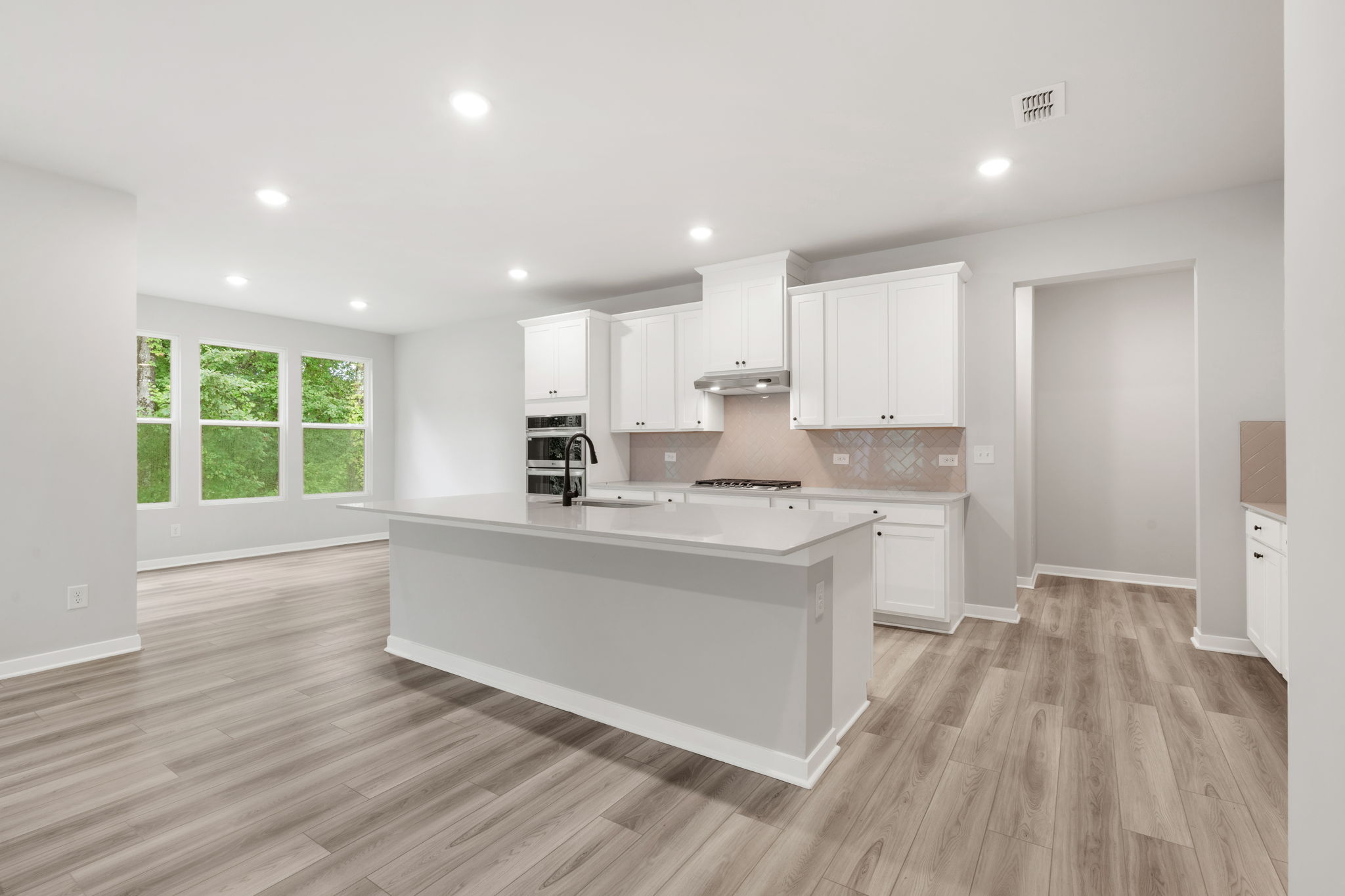 A kitchen with white cabinets.