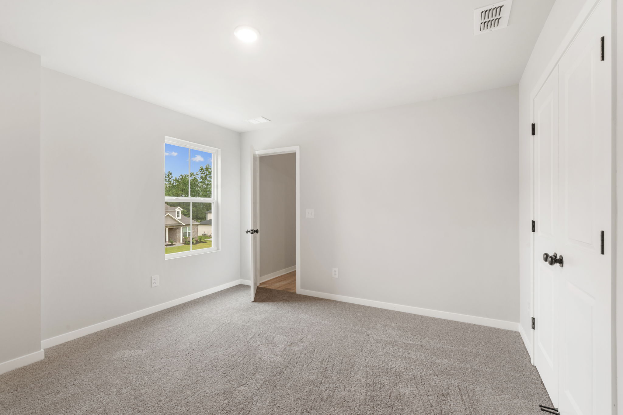 A room with white walls and a window.