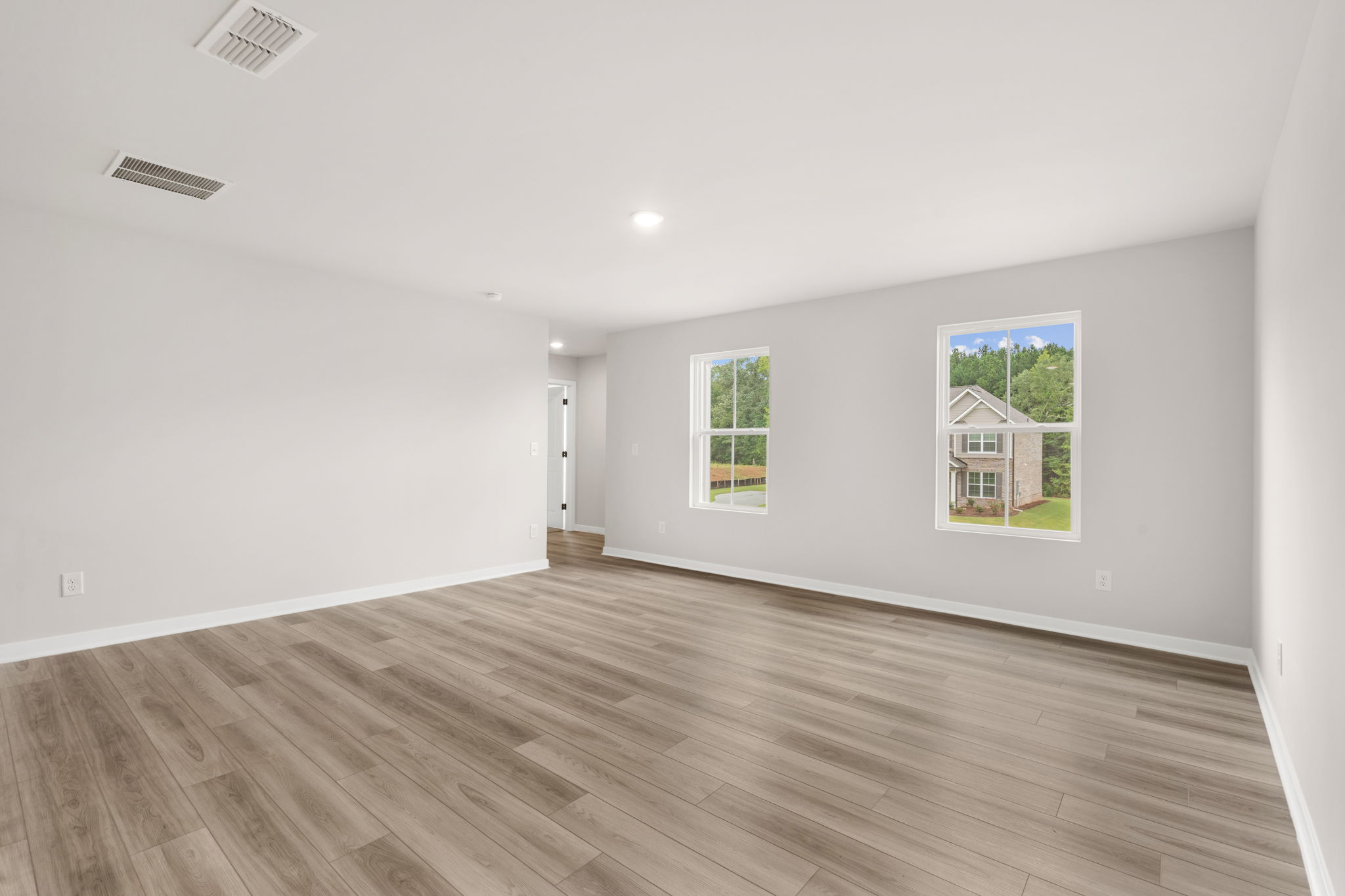A room with a wood floor and windows.